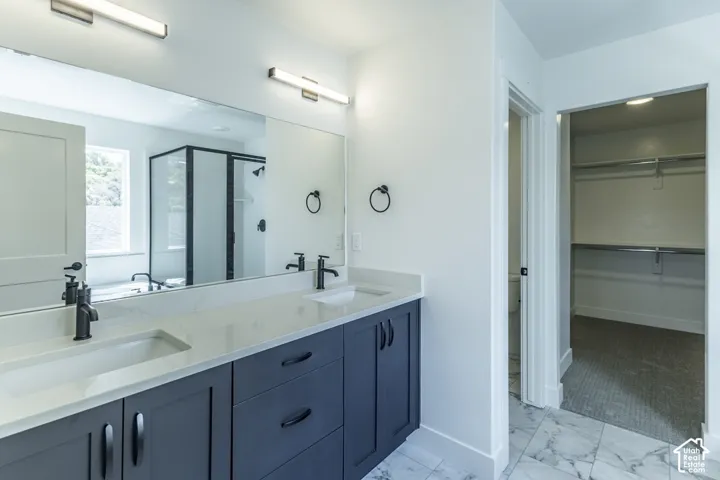Dual vanity with undermount sinks, white countertop, and dark cabinetry