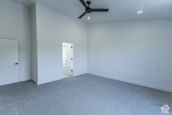 Recessed lighting, ceiling fan, and light-toned carpet