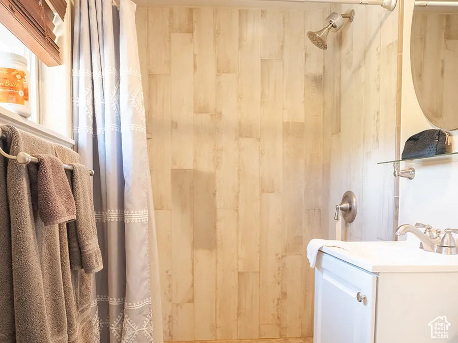 Walk-in shower with vertical plank wall tiling and pebble-style flooring