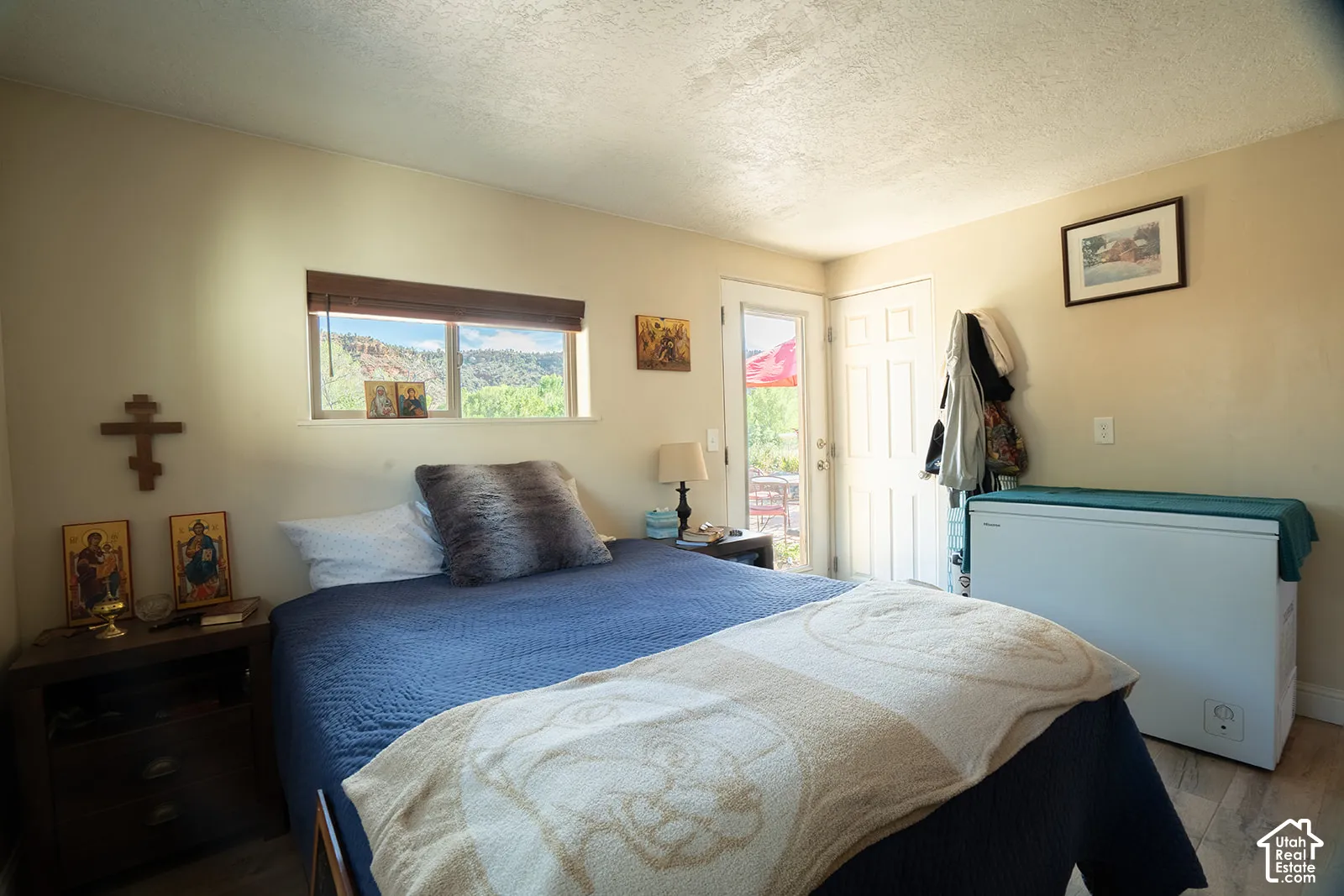 Interior space featuring light-colored walls and a window with wood-tone blinds