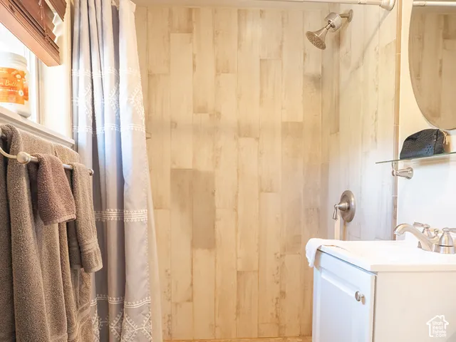 Walk-in shower with vertical plank wall tiling and pebble-style flooring