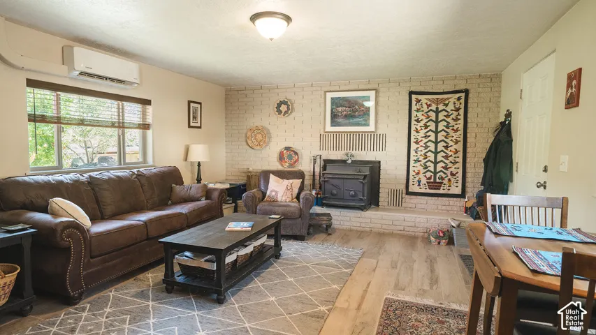 Wood-finish flooring throughout, paired with a white-painted brick fireplace and hearth