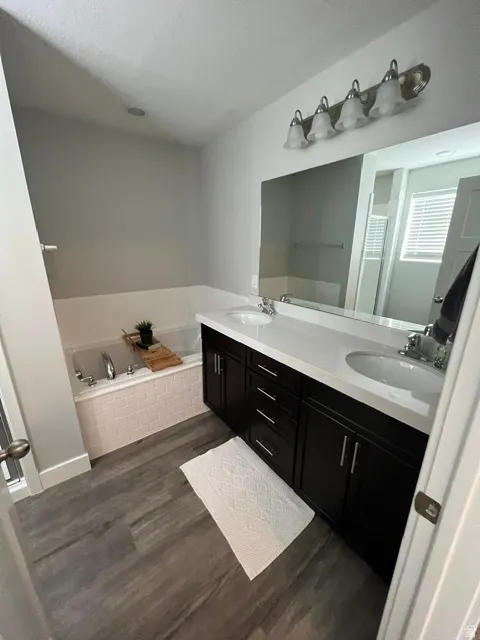 Bathroom featuring a dual vanity with dark wood cabinetry, white countertops, and undermount sinks
