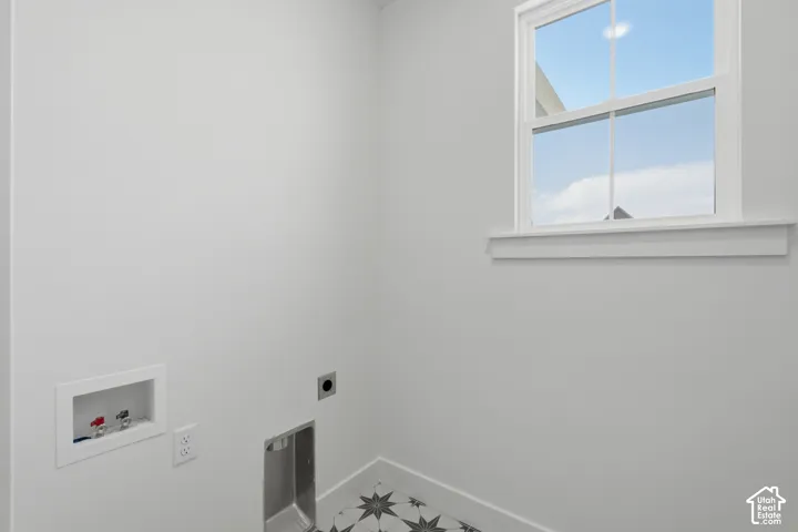 White walls, a white-framed window, and patterned floor tiles