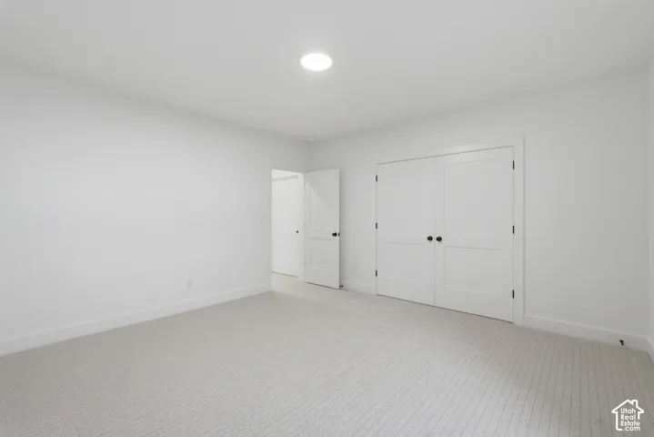 Recessed ceiling lighting, light-toned carpeting, white walls, and white paneled doors with dark hardware