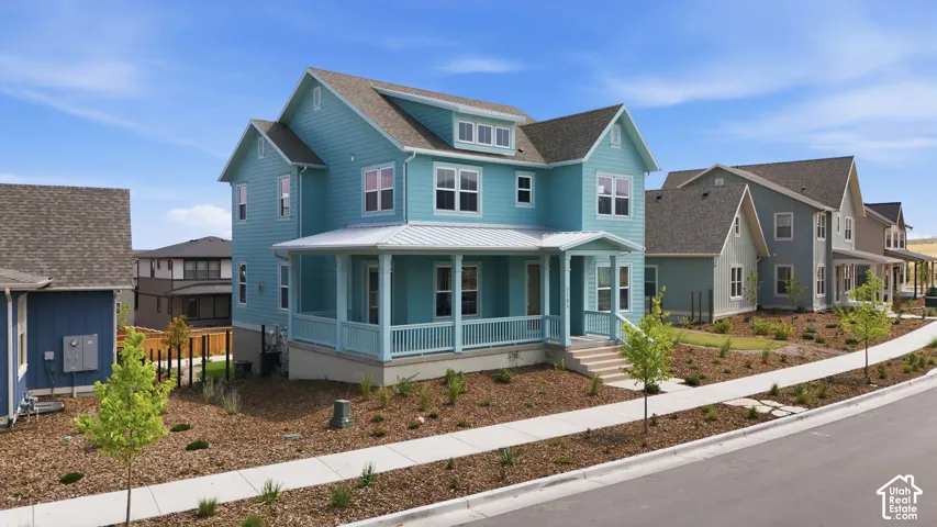 Two-story residence featuring light blue siding, a covered porch with white columns, and a gray shingled roof