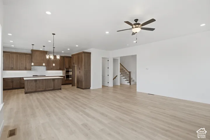 Spacious area featuring light wood-finish flooring, recessed lighting, and a ceiling fan