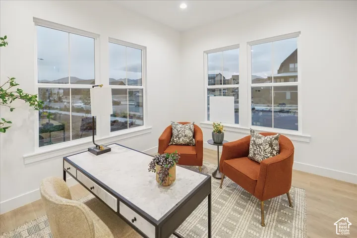 Bright room featuring wood-finish flooring, four multi-pane windows, and recessed ceiling lighting