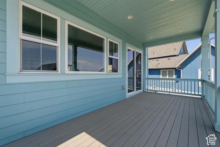 Covered porch with composite decking, recessed lighting, and a sliding glass door