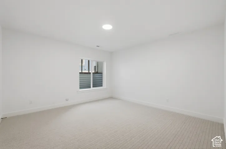 Recessed ceiling lighting, white painted walls, white trim, and light-colored carpet flooring