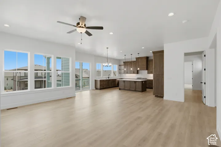 Open concept living space featuring light wood-finish flooring, a contemporary ceiling fan, and recessed lighting