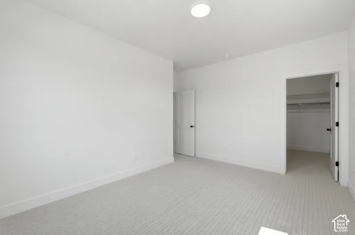 Recessed ceiling light fixture, white walls, light-toned patterned carpet, and white trim