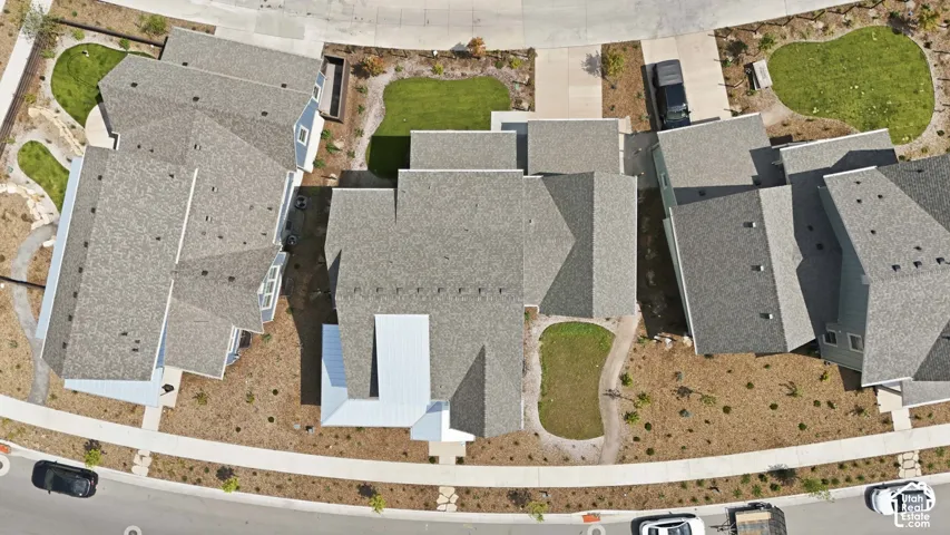Pitched rooflines, multiple residential structures, concrete pathways, and landscaped green spaces