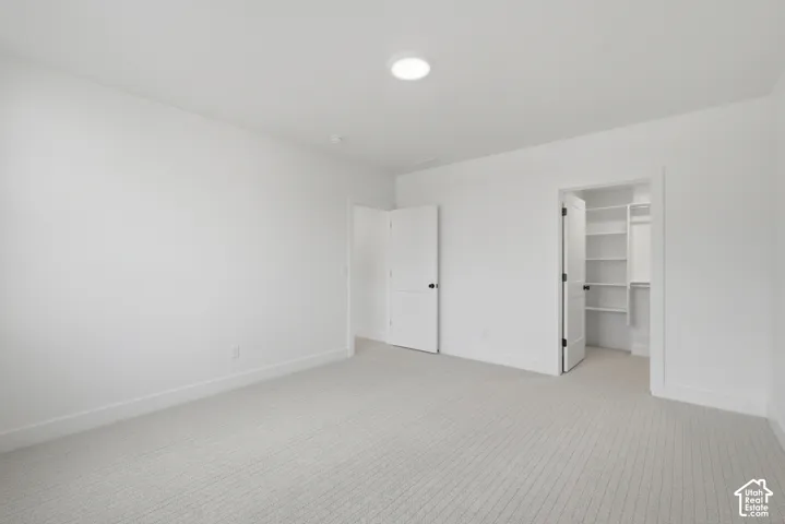 Recessed lighting, light-toned carpet, white walls, white trim, and a built-in closet system