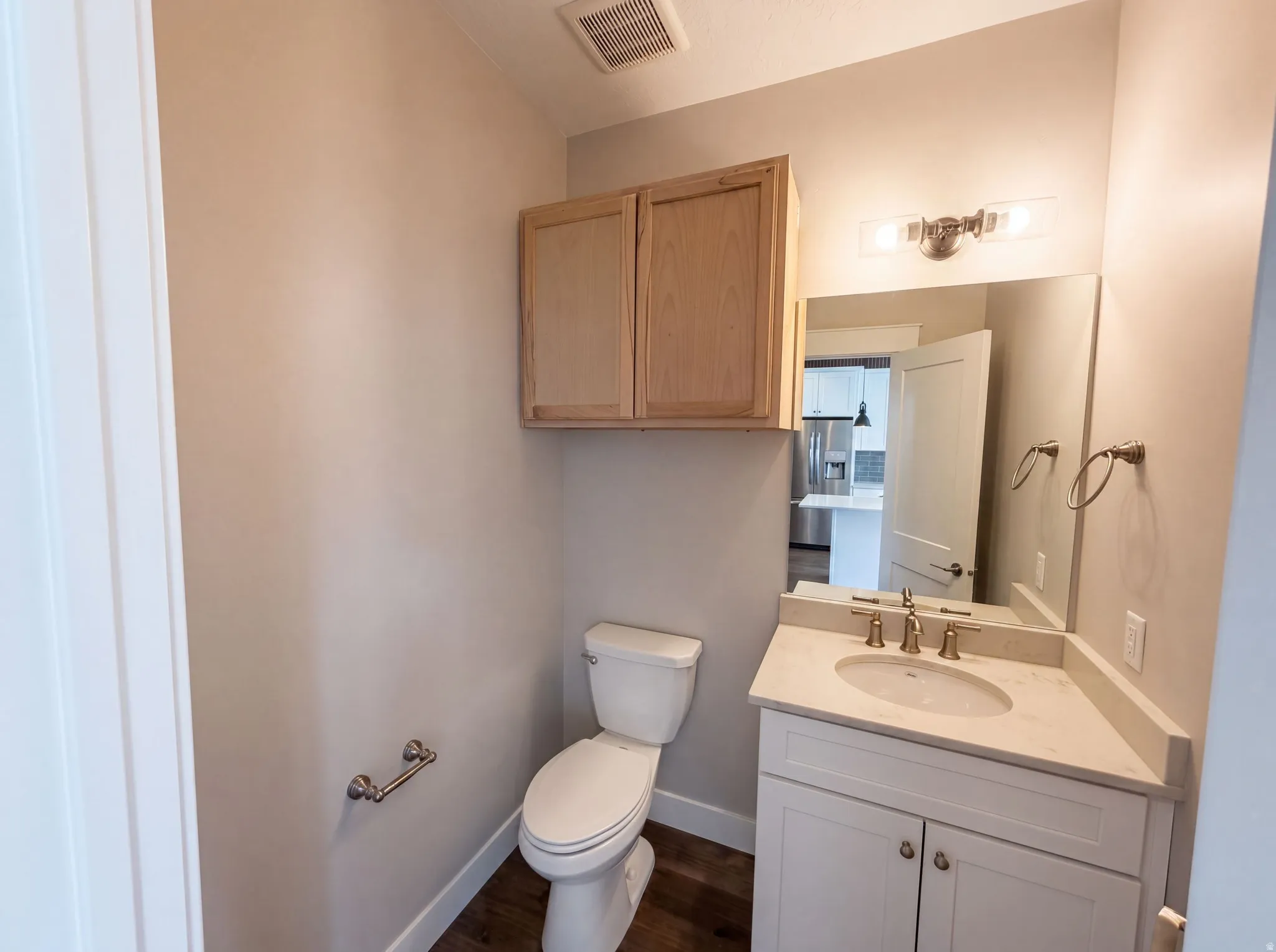 Corner vanity with an undermount sink, a bronze-finish faucet, and a wall-mounted mirror