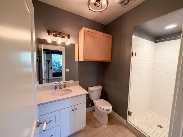 White vanity with brushed nickel hardware, light countertop, and a single basin sink
