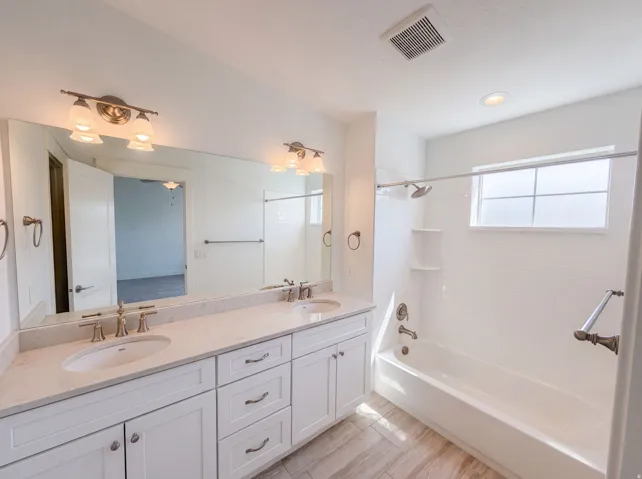 Dual vanity with undermount sinks, stone countertop, and brushed nickel fixtures