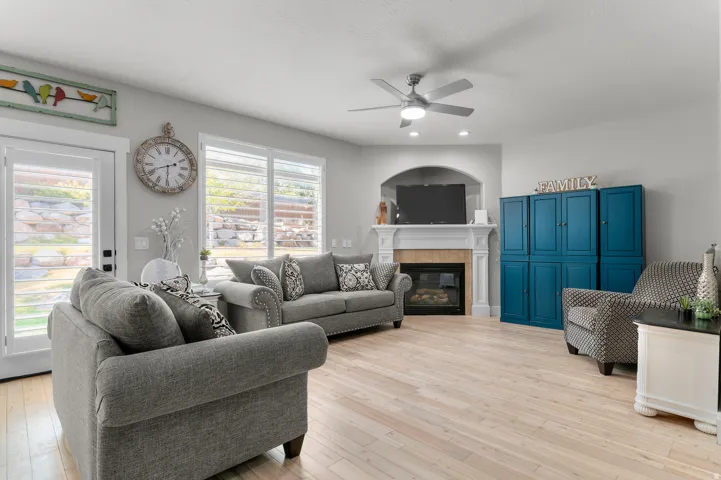 Light wood-finish flooring, recessed lighting, and a ceiling fan create a comfortable atmosphere