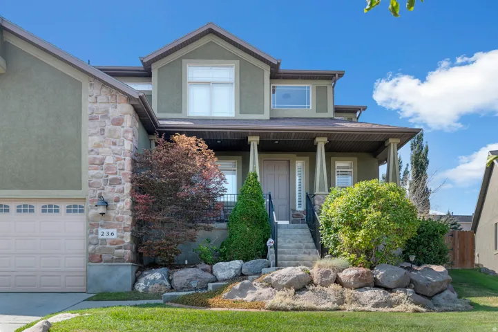 Multi-level residence featuring a stone and stucco exterior