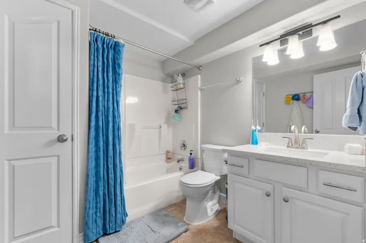 White vanity with a light-colored countertop and undermount sink