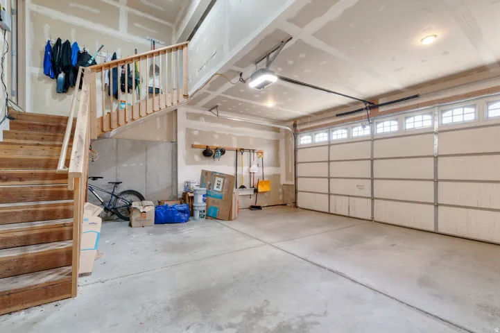 Garage with a concrete floor, overhead lighting, and an automatic garage door opener