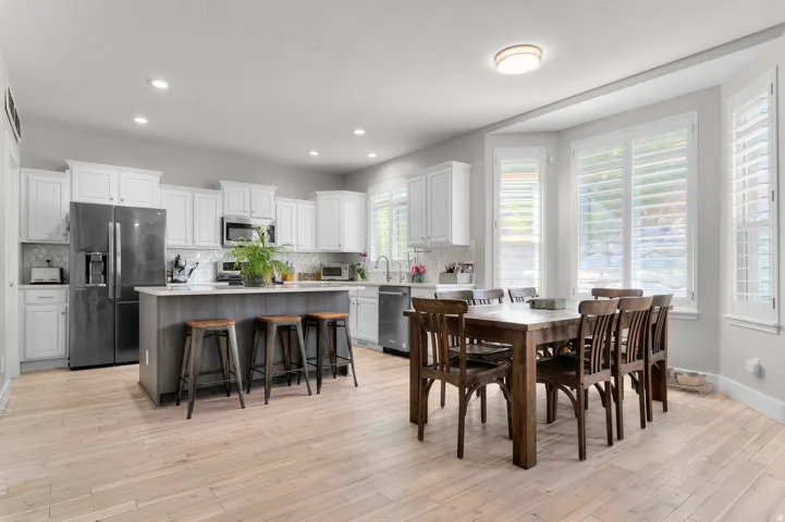 Open-concept kitchen and dining area featuring light wood-finish flooring
