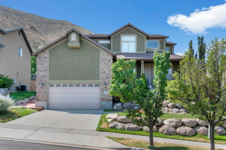 Two-story residence featuring a stone and stucco exterior