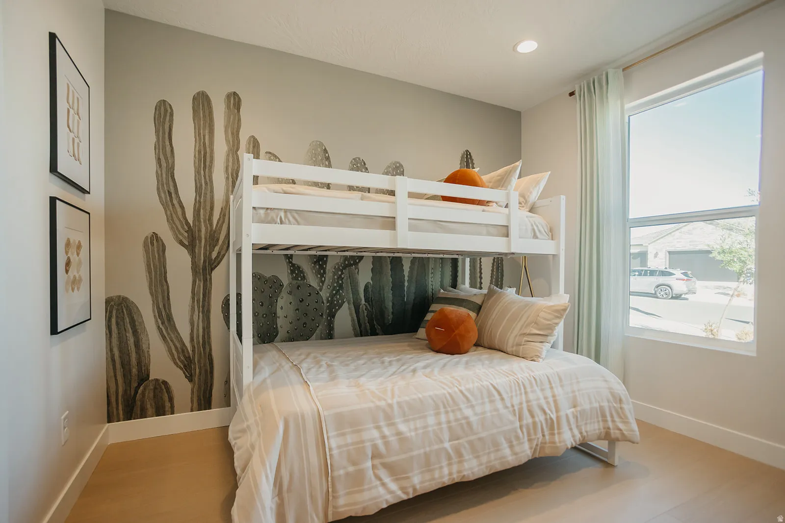 Recessed ceiling lighting, light-toned wood-finish flooring, a large window, and a decorative wall mural