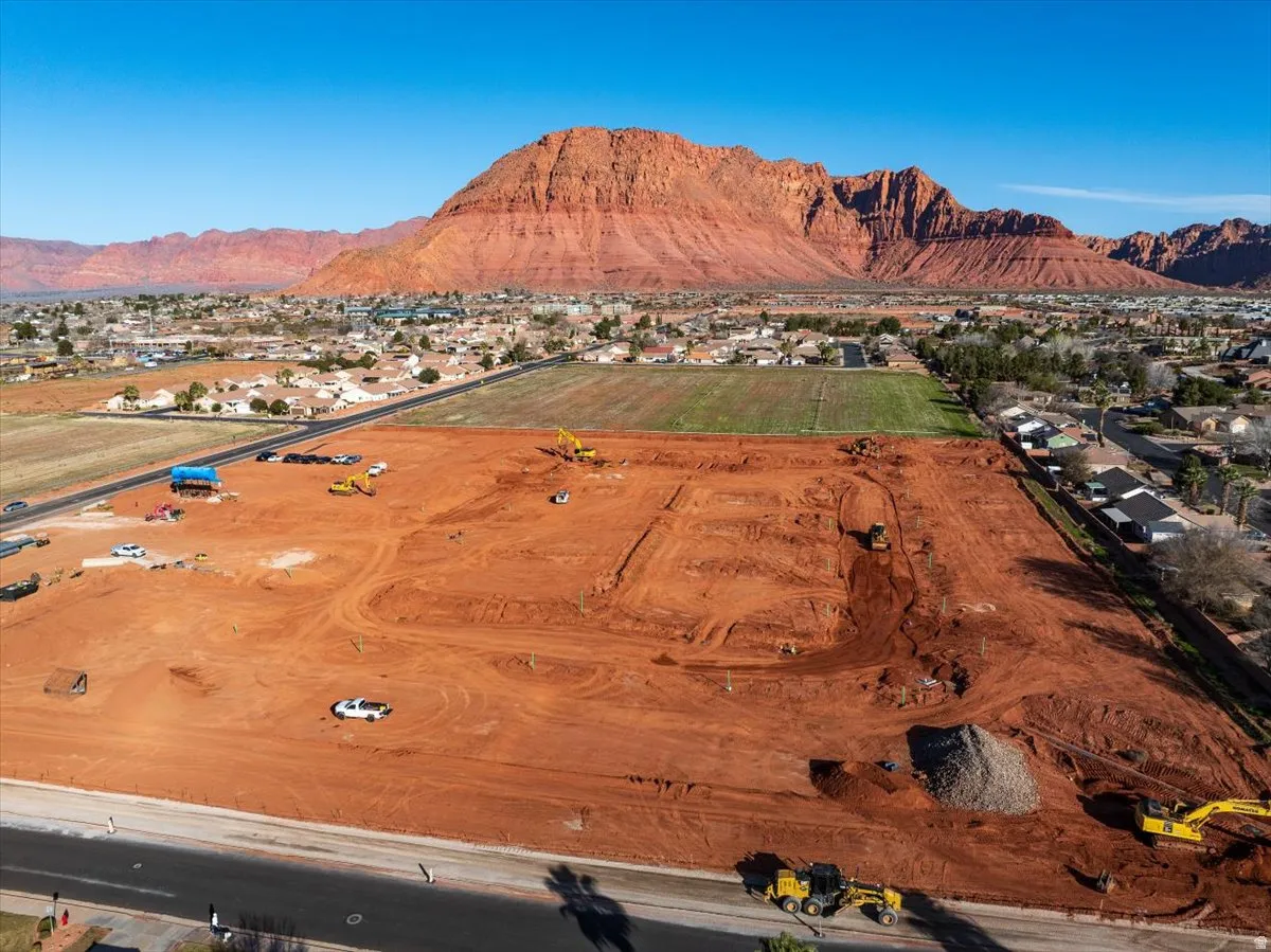 Expansive lot with red earth grading, bordered by a paved road