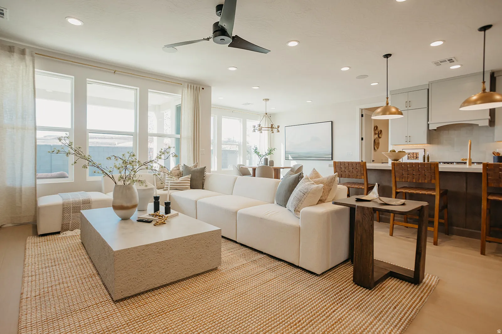 Open-concept living space featuring recessed lighting, a modern ceiling fan, and large windows