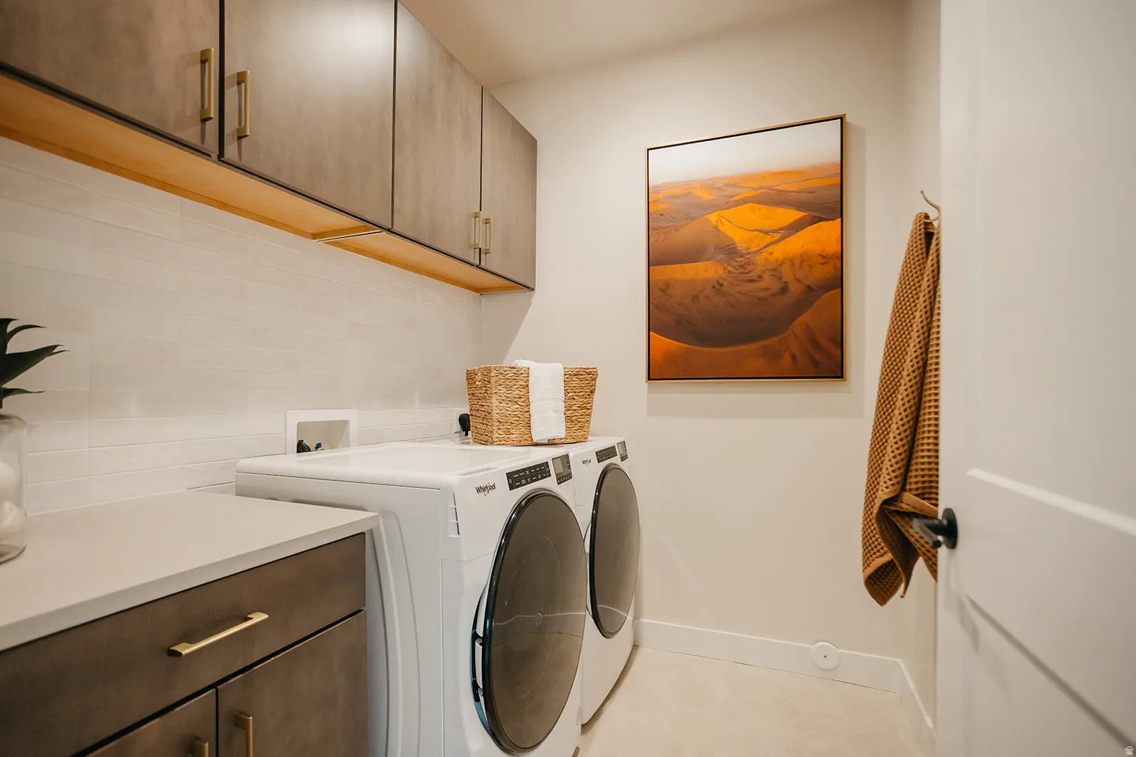 Upper cabinetry with brass hardware, wood-finish shelving, and a tiled backsplash