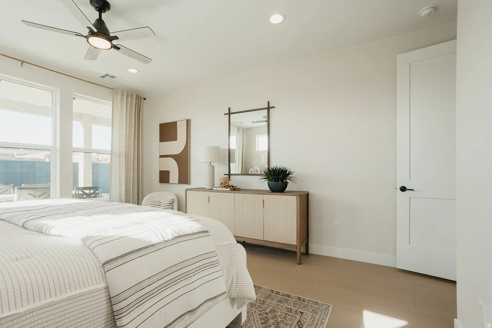 Recessed lighting, ceiling fan with integrated light, wood-finish flooring, white walls, and a flat-panel interior door