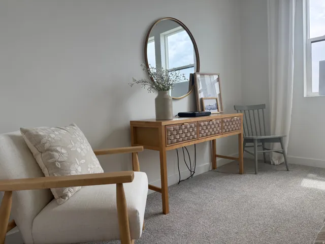 Light gray wall color, wall-to-wall carpeting, and a window with white window treatments