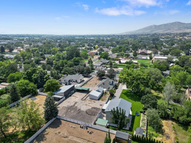 Expansive property featuring multiple outbuildings, fenced perimeters, and a large residential structure with a gray roof
