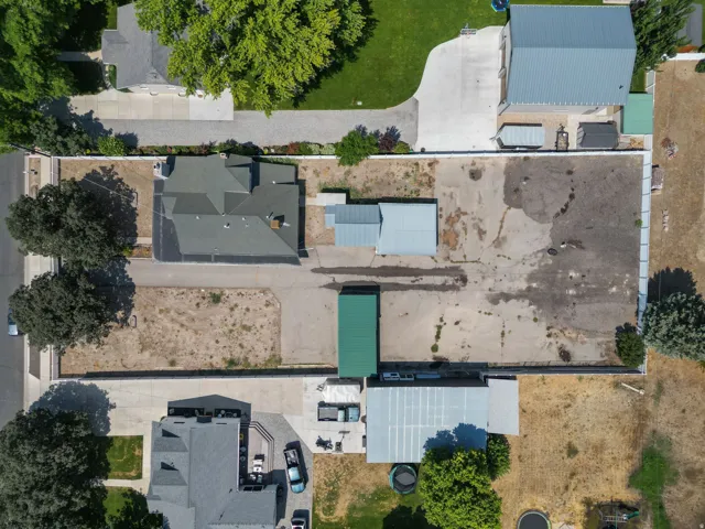 Main residence with a dark-pitched roof, paved driveway, and detached ancillary building