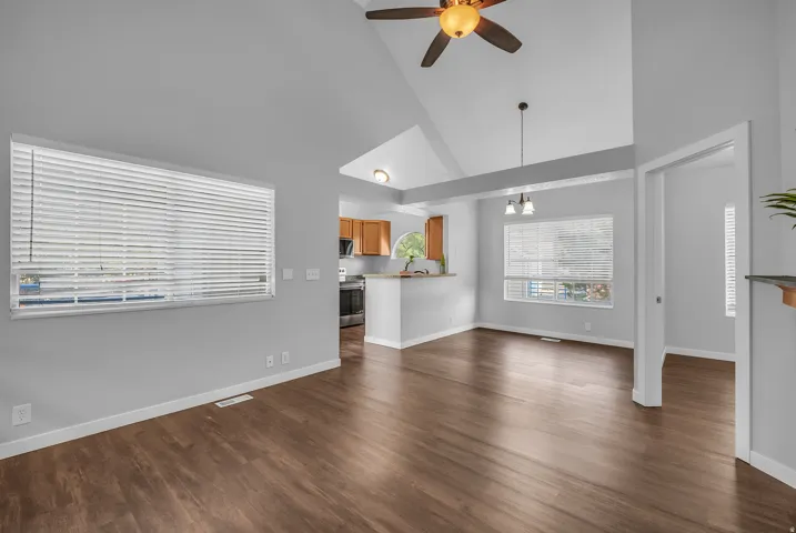 Vaulted ceilings, wood-finish flooring, ceiling fan, recessed lighting, and kitchen pass-through