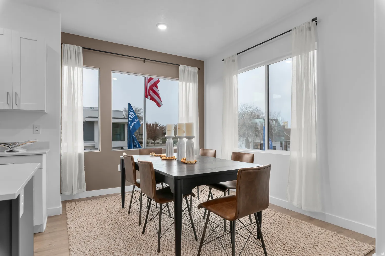 Recessed lighting illuminates the dining space, featuring a dark-finish dining table