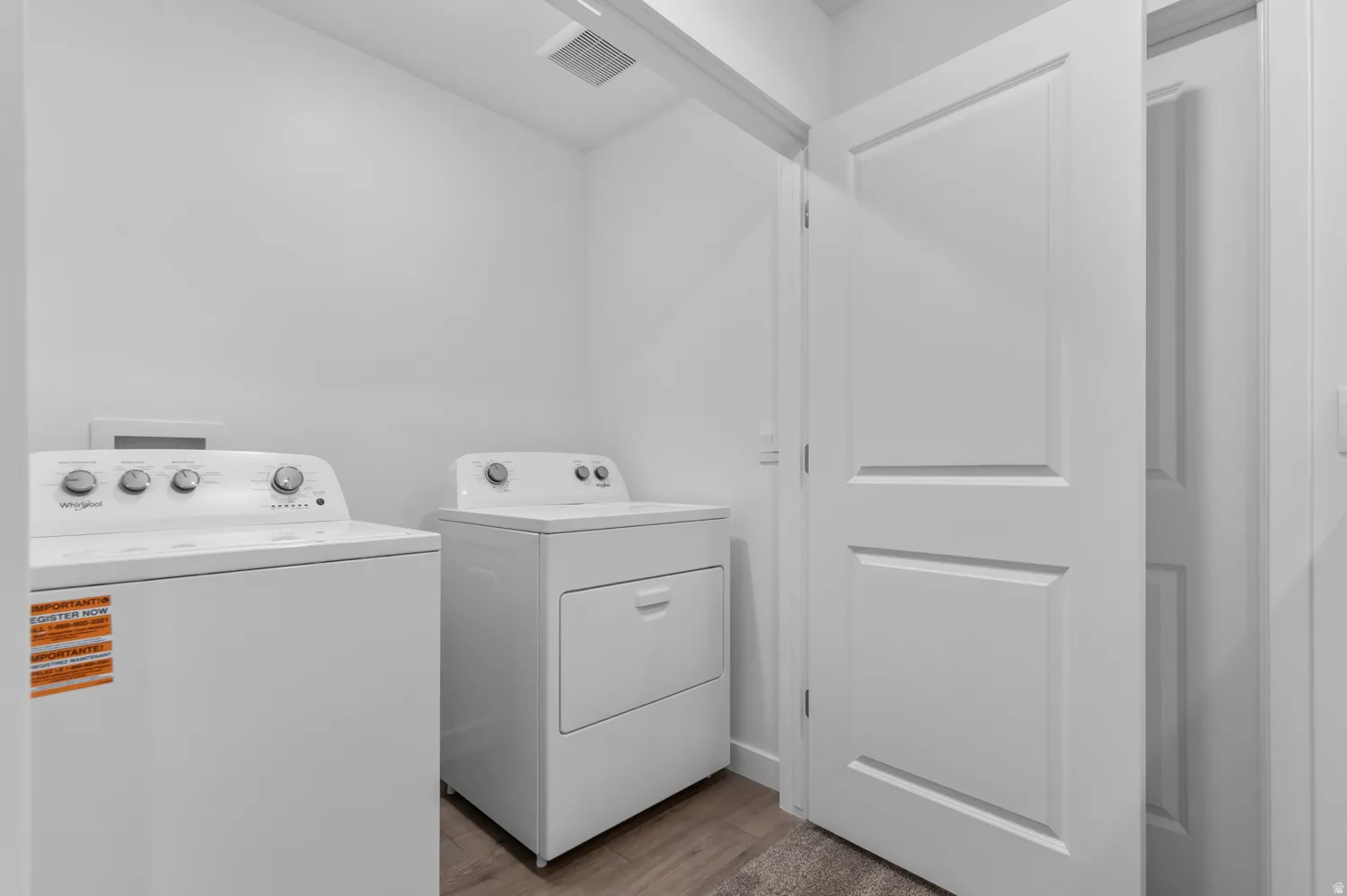 Laundry area with wood-finish flooring