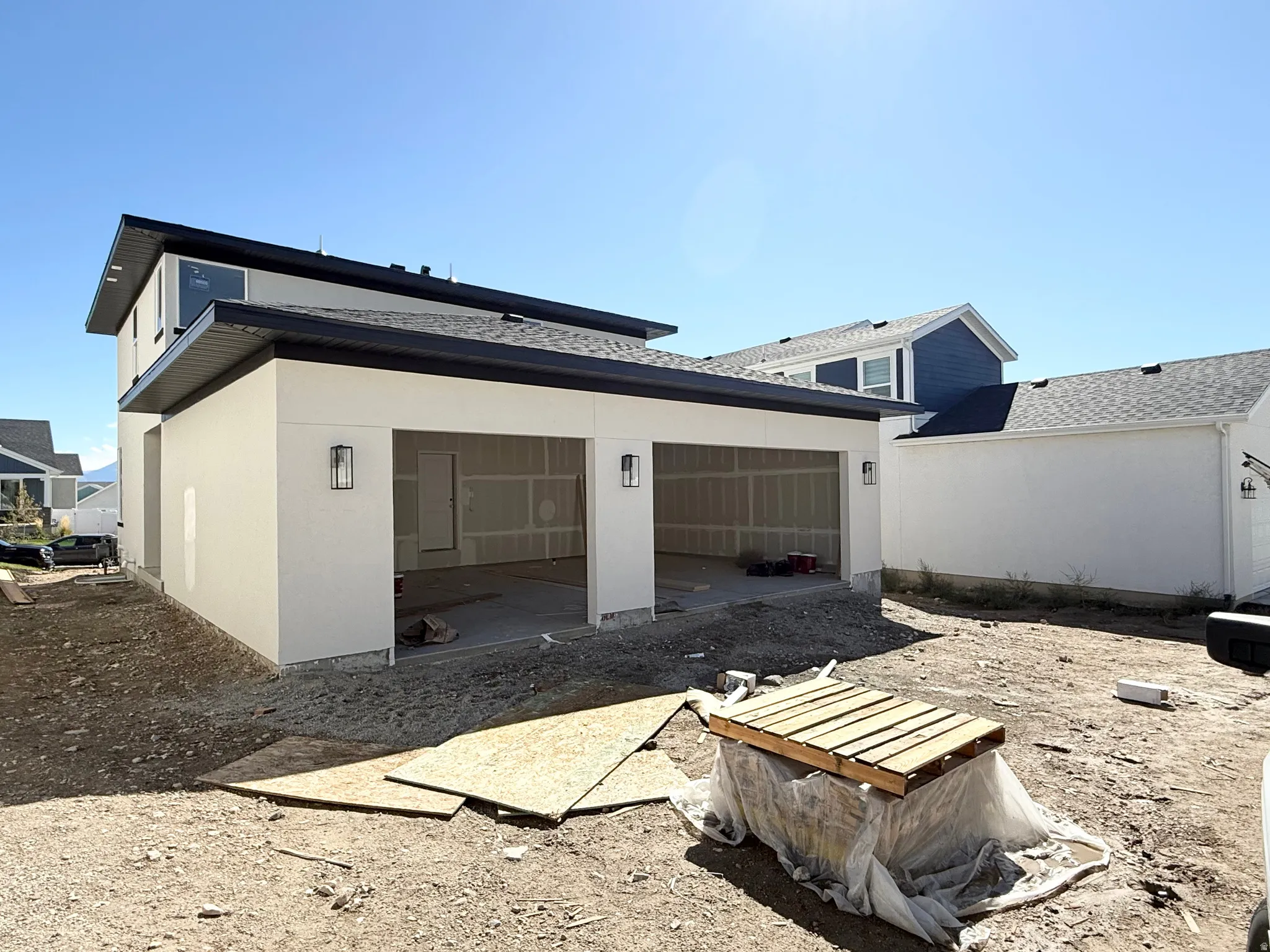 Two-car garage with modern outdoor lighting fixtures and a second-story structure