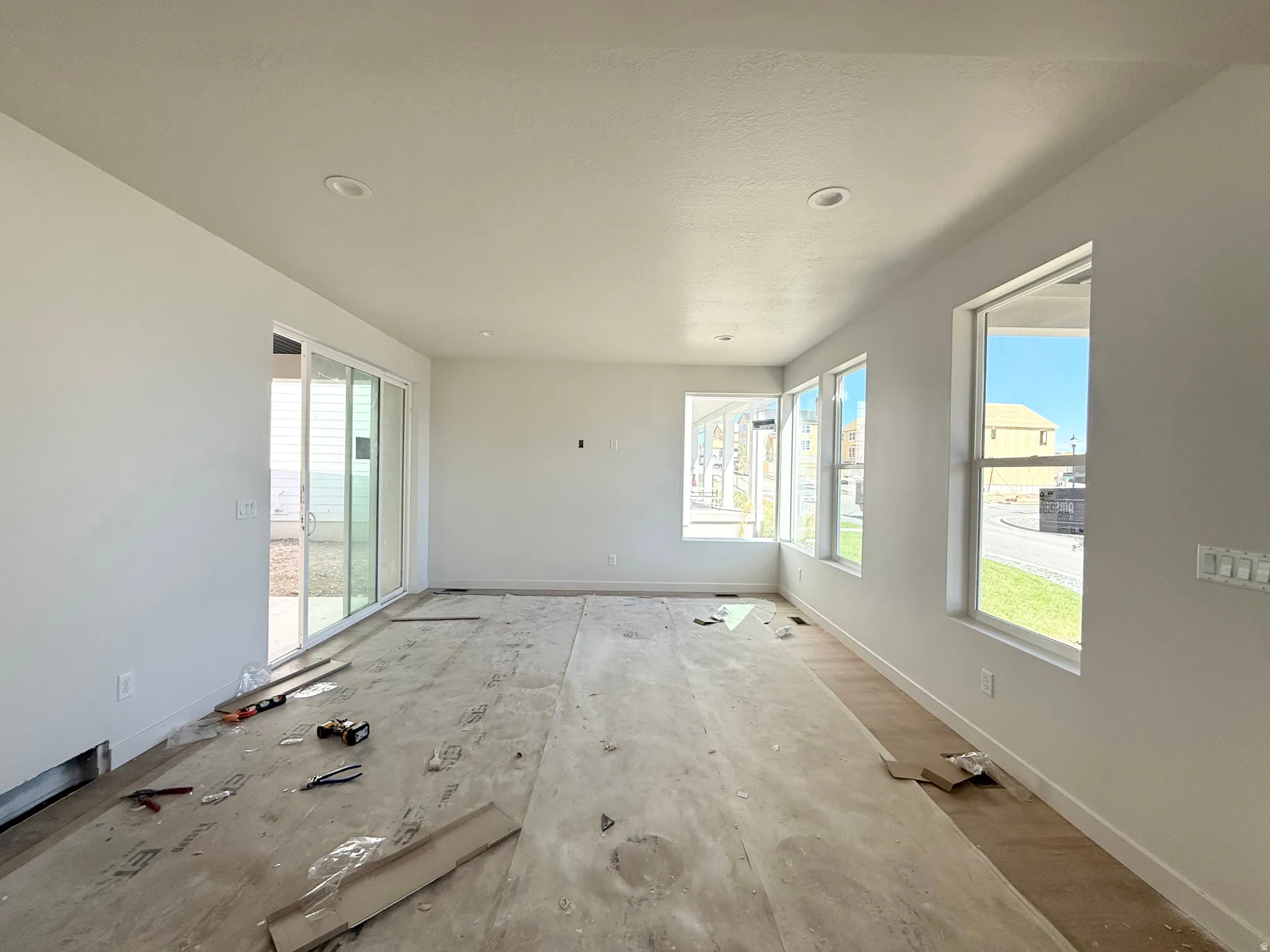 Recessed lighting and multiple windows illuminate this space, featuring a sliding glass door
