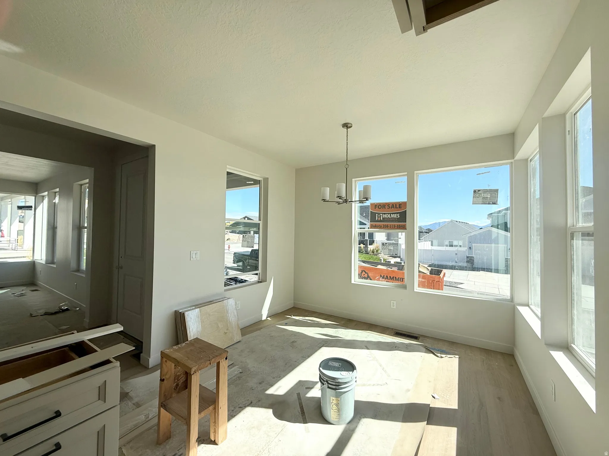 Recessed lighting, wood-finish flooring, white walls, and a chandelier with a brushed nickel finish