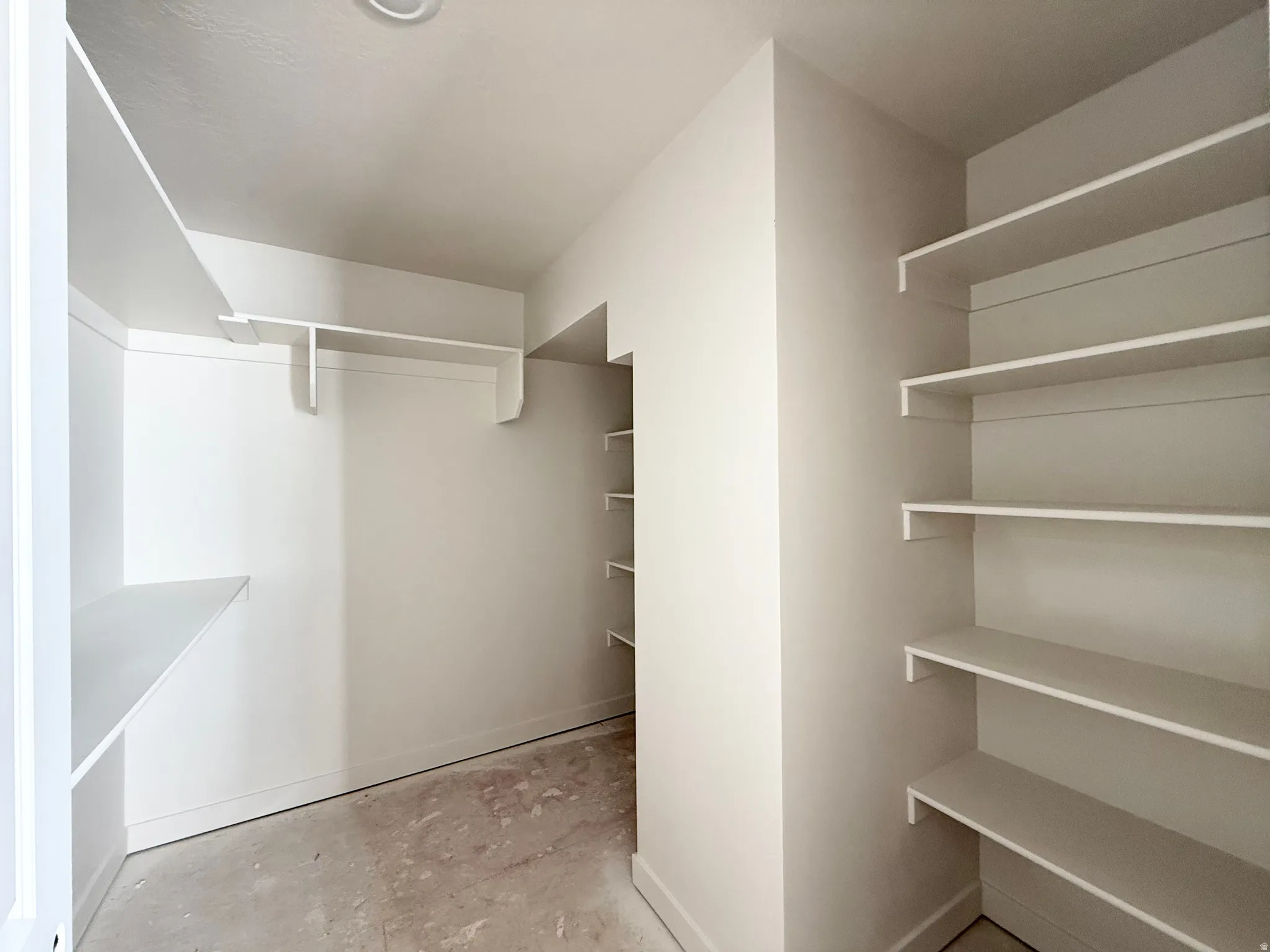 Walk-in closet with extensive built-in shelving, hanging rod, and recessed ceiling lighting