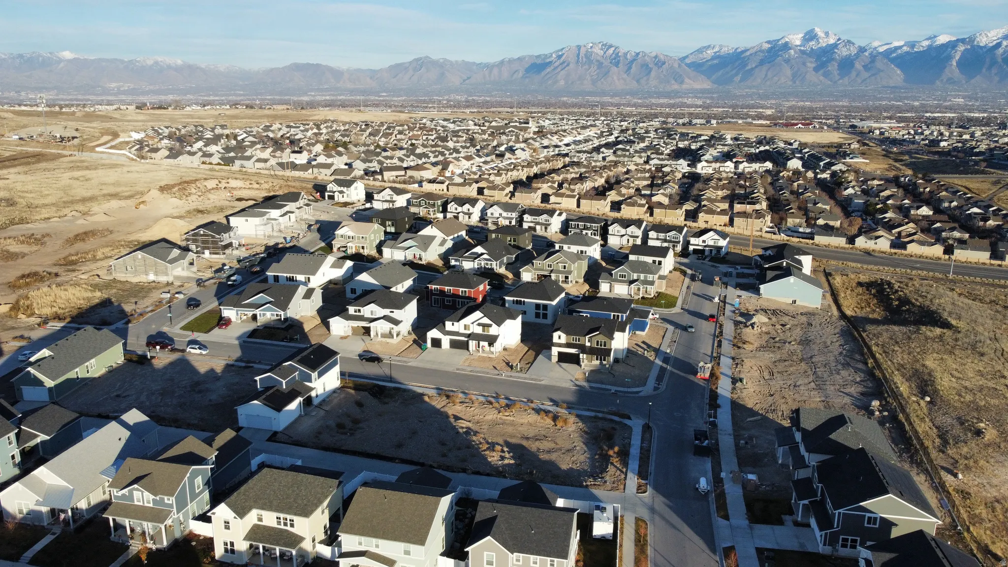 New construction development with a variety of architectural styles, paved streets, and a mountain backdrop