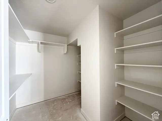 Walk-in closet with extensive built-in shelving, hanging rod, and recessed ceiling lighting