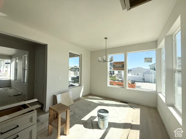 Recessed lighting, wood-finish flooring, white walls, and a chandelier with a brushed nickel finish