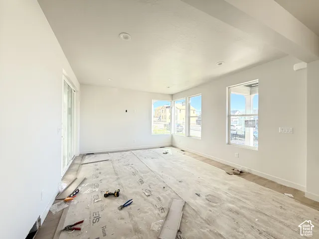 Spacious room featuring multiple windows, a sliding glass door, recessed lighting, and neutral wall tones