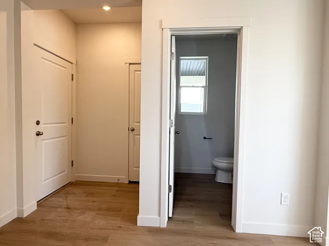 Wood-finish flooring throughout, white interior doors, and a recessed ceiling light