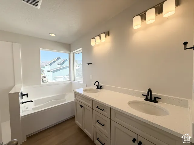 Dual vanity with white cabinetry, matte black hardware, and an integrated white countertop
