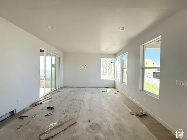 Recessed lighting and multiple windows illuminate this space, featuring a sliding glass door