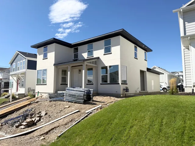 Modern two-story stucco exterior with a black trim roofline and white window frames
